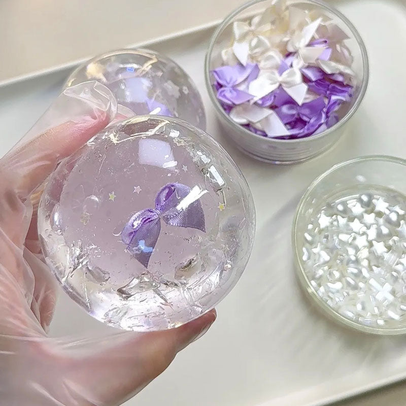 Hand holding a 6cm handmade crystal squishy ball for size reference